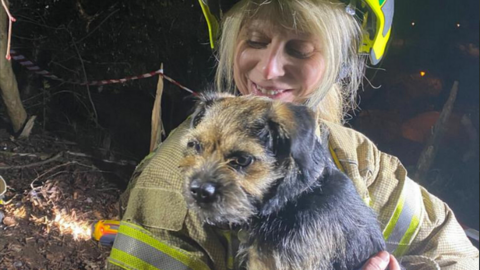 Coco the dog with a member of Gloucestershire Fire and Rescue Service