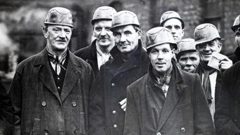 A group of miners at the West Cannock Colliery, Staffordshire, wearing helmets and carrying safety lamps, circa 1940.