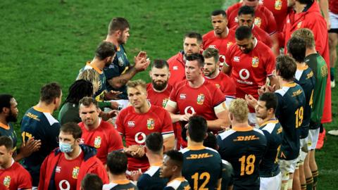 The Lions look disappointed as they walk through a tunnel of South Africa players