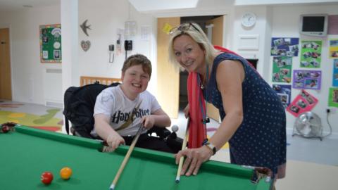 Clare Periton playing pool with a child in the hospice