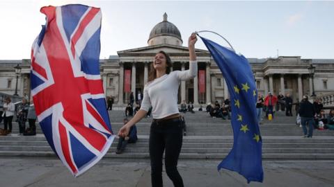 A Pro-European Union protester holds Union and European flags in Trafalgar Square