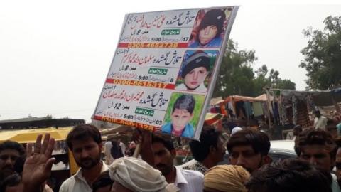 Protesters in Kasur with posters showing the missing boys