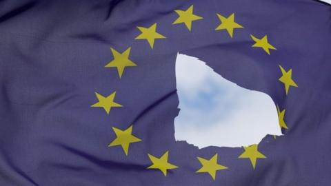 An EU flag, with a hole cut in the middle, flies at half-mast outside a home in Knutsford, Britain. Photo: 24 June 2016