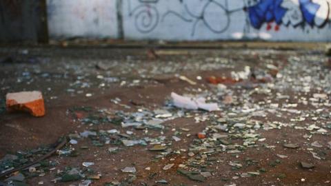 Broken glass and graffiti on wall