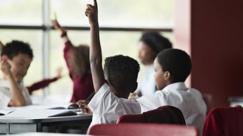 Raised hands in classroom