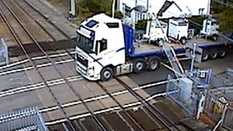 Lorry reverses into level crossing