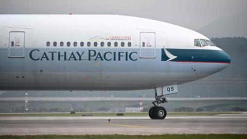 A Cathay Pacific plane lands on the tarmac