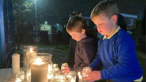 Boys lighting candles