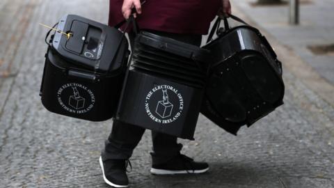 A man holding ballot boxes