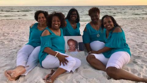 Photo of the Sensational Six on the beach in Florida, holding a photo