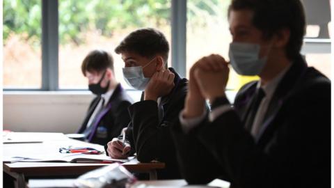Students at their desks wearing masks