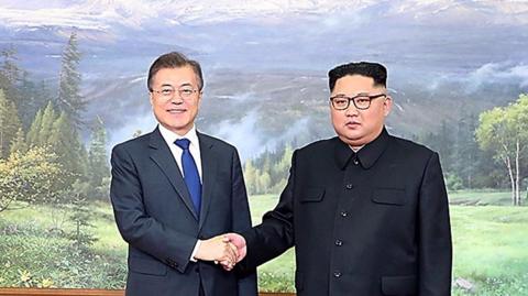 Moon Jae-in shakes hands with Kim Jong-un