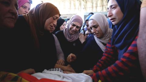 Relatives of Mohammed al-Alami mourn during his funeral near Hebron in the occupied West Bank (29 July 2021)