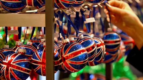 A customer looks at Union Jack decorated Christmas tree baubles in a John Lewis department store