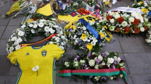 lowers placed by Swedish Prime Minister Ulf Kristersson and Belgian Prime Minister Alexander De Croo are seen among other items left as a tribute to the victims two days after a gunman shot dead two Swedes, at the place of the shooting in Brussels, Belgium October 18, 2023