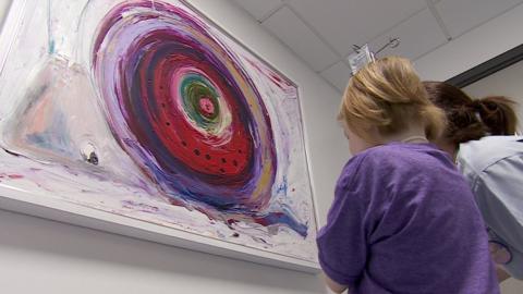 Sadie looks at a painting of a snail at the Royal Hospital for Sick Children