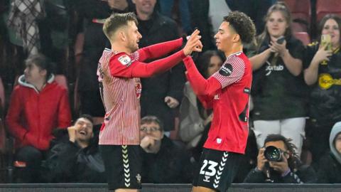 Stuart Armstrong (left) and Samuel Edozie clap hands to celebrate a goal