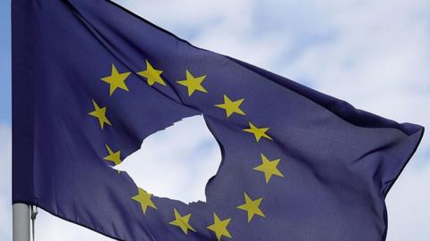 A European Union flag, with a hole cut in the middle