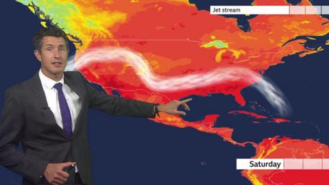 Chris Fawkes stands in front of a weather map showing heat in the USA