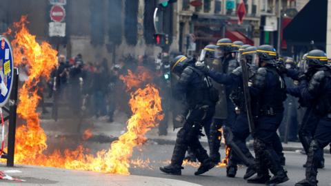 Riot police deal with a petrol bomb in Paris. 1 May 2017