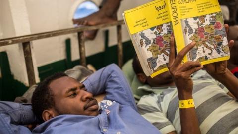 A migrant reads on the deck of the boat of the NGO Proactiva Open Arms on July 1, 2018.