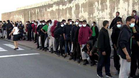 Migrants wait near the emergency camp in Gran Canaria