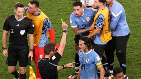 Edinson Cavani is booked during Uruguay's game with Ghana at the World Cup