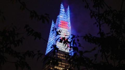 The top of London's Shard lit up in colourful lights