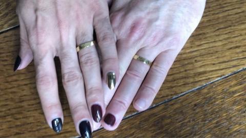 Couple who have just got married show off their wedding rings