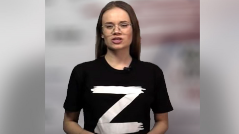 Female presenter wearing black t-shirt bearing the letter "Z"