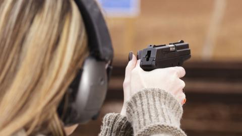 A woman firing a gun