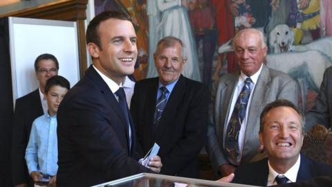 French President Emmanuel Macron (L) shakes hands with a voting official after voting in the second round of the French legislative elections at the City Hall in Le Touquet, France, 18 June 2017.