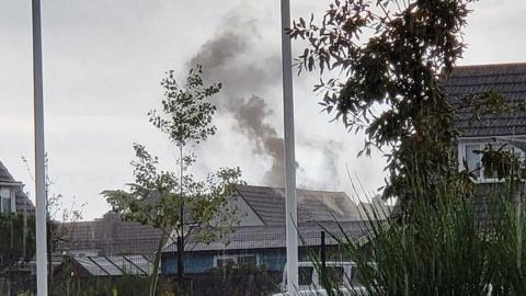 Smoke rises from house in the distance