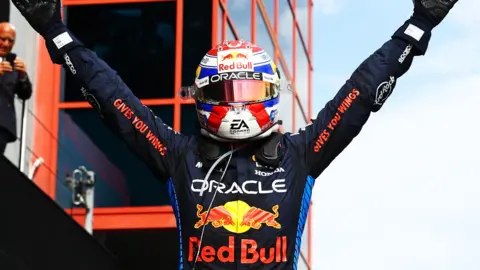 Max Verstappen lifts his arms aloft to celebrate winning the Emilia Romagna Grand Prix