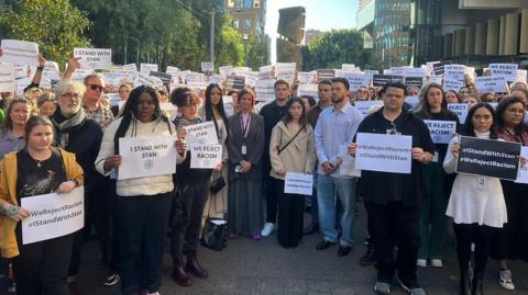 ABC employees hold signs in support of Stan Grant