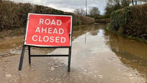Flood water and road closed sign