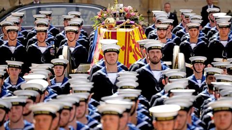 The coffin of Queen Elizabeth II with the Imperial State Crown resting on top, borne on the State Gun Carriage of the Royal Navy departs Westminster Abbey on September 19, 2022 in London