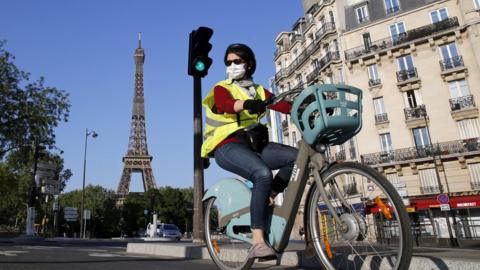 A woman cycles in Paris