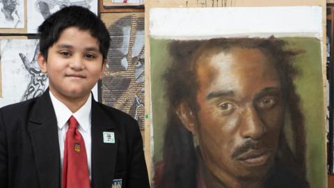 Izaan next to drawing of Benjamin Zephaniah