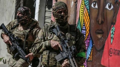 Members of the Military Police carry out an operation at the Alemao favela