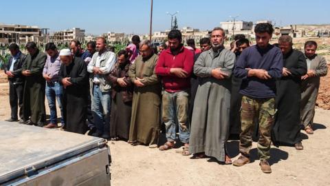 Syrians hold funeral prayers before they bury the bodies of victims of a a chemical attack in Khan Sheikhoun, Idlib province, 5 April