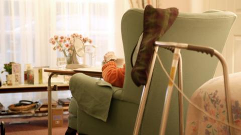 Person sitting in chair in care home