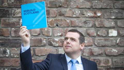 Douglas Ross raises up the Scottish Conservative manifesto