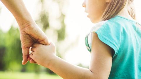 Mother holding a girl's hand