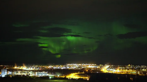 A view of the Northern Lights over Reykjavik before the street lights were turned off