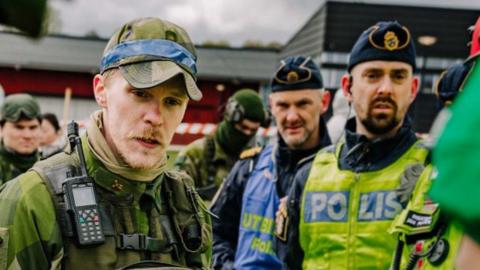 Swedish soldier beside police officer