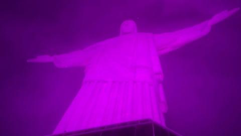 Pink light shines on Christ the Redeemer statue
