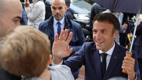 rench President Emmanuel Macron greets supporters as he leaves after voting in the second round of French parliamentary elections, at a polling station in Le Touquet-Paris-Plage, France, June 19, 2022.