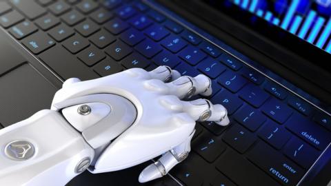 Robot hand on keyboard