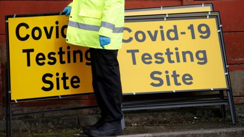 A man in a high-vis jacket at a coronavirus testing site